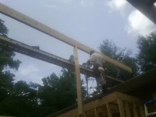 Carpenter setting a ridge beam over a new addition frame — Ice Dam Removal by Roofing Brothers in Kimbolton