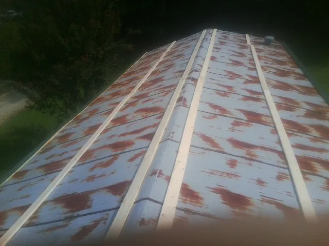 Rusted metal roof panels with new wood purlins before replacement — Storm Damage Roof Repair in Kimbolton by Roofing Brothers