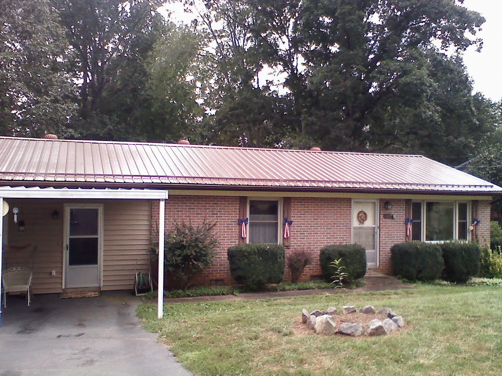 Bronze metal roof and carport on a brick ranch home — Roof Repair work by our crew in Kimbolton